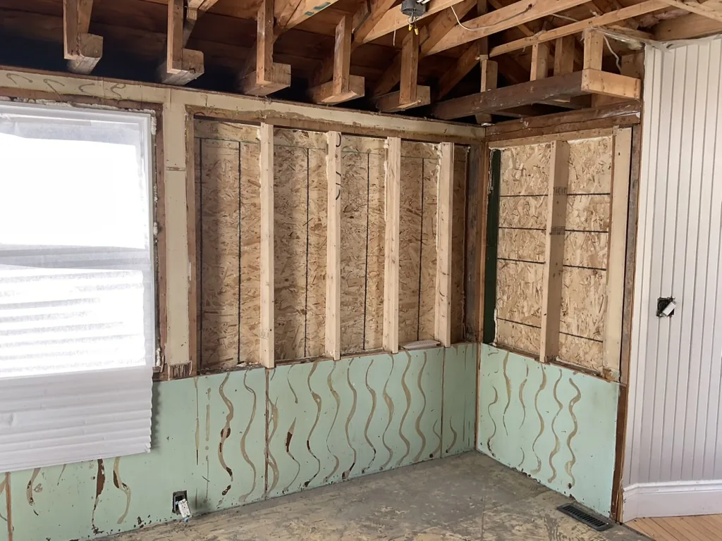 A corner of the kitchen stripped to the sheathing under a double window, Schomberg Ontario