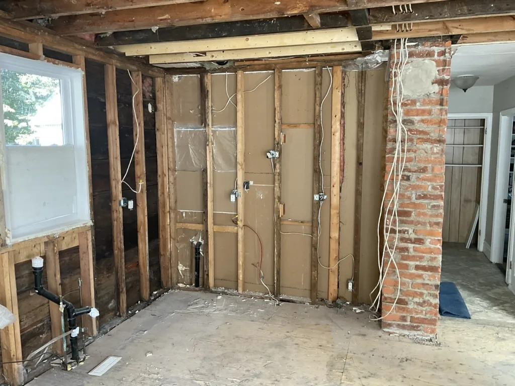 The range wall stripped to the studs beside an old brick chimney, Schomberg Ontario
