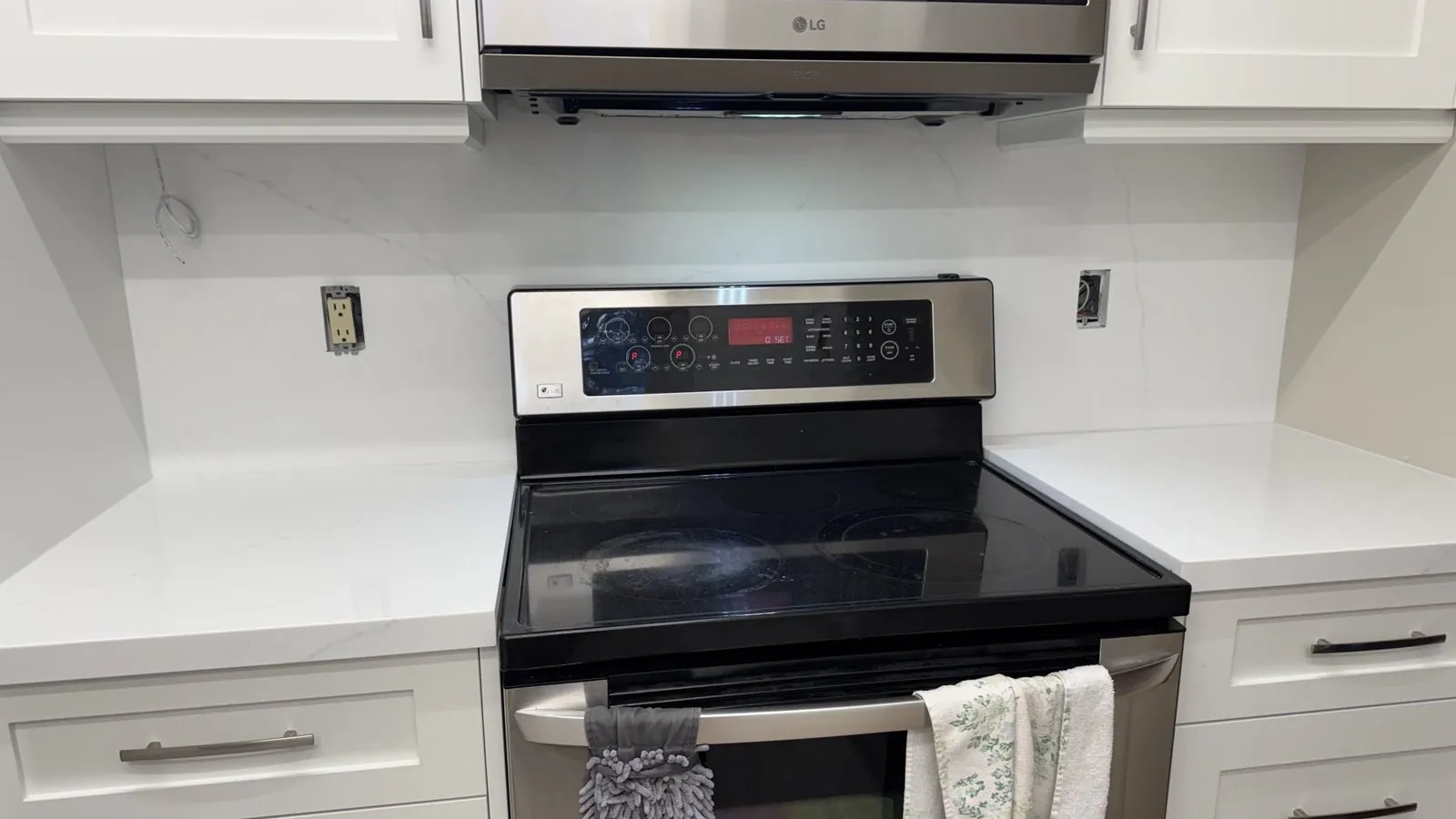 The same range wall with white Viatera Velo quartz countertops and a full-height quartz slab backsplash with soft grey veining, Whitchurch-Stouffville Ontario