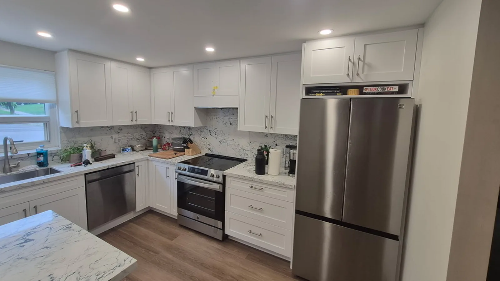 White shaker uppers to the ceiling, a cabinet over the fridge and white quartz with dark veining from the counter up to the uppers, Aurora Ontario