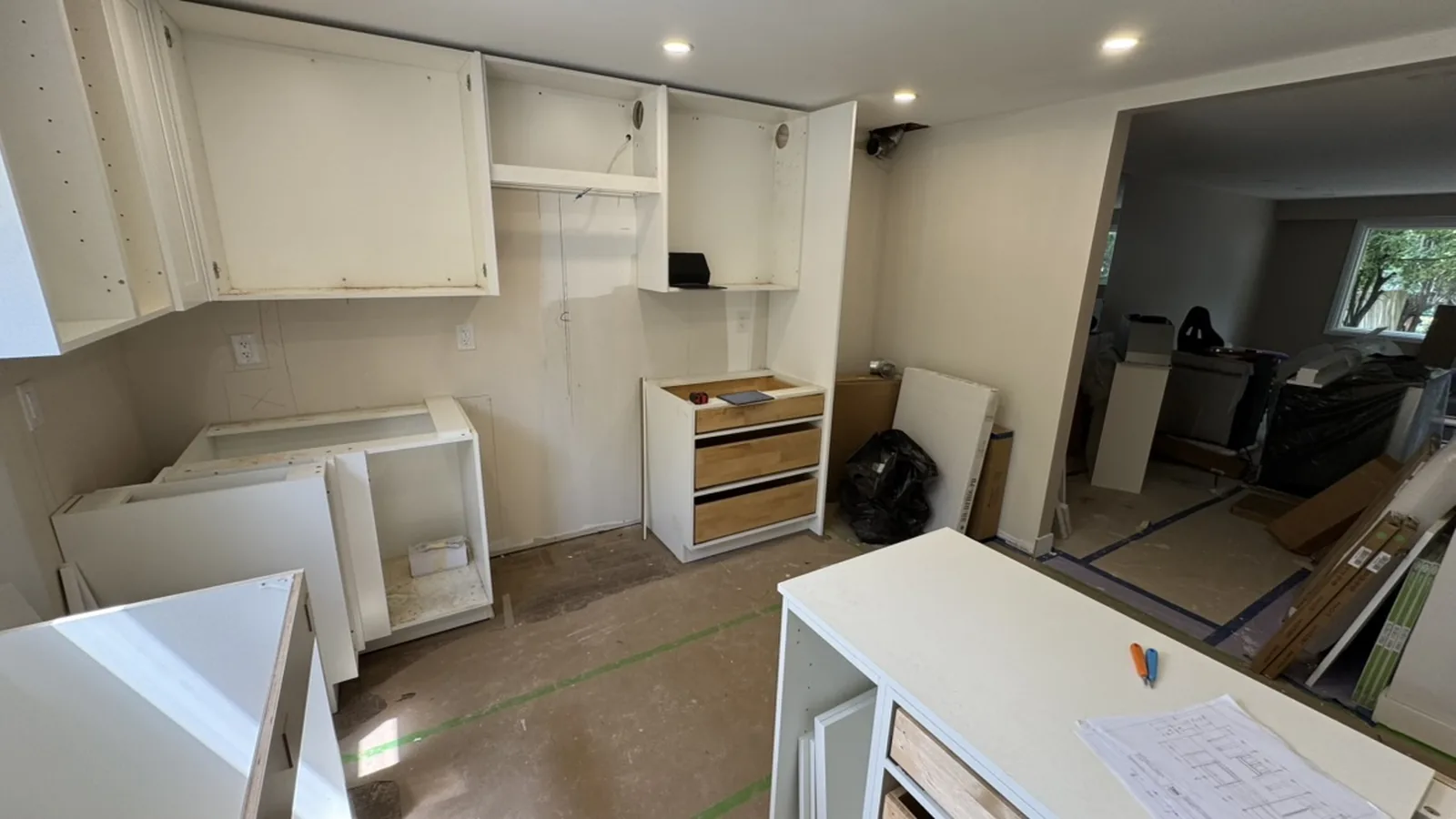 White cabinet boxes going in on the range and fridge wall, doors off and no countertop yet, Aurora Ontario